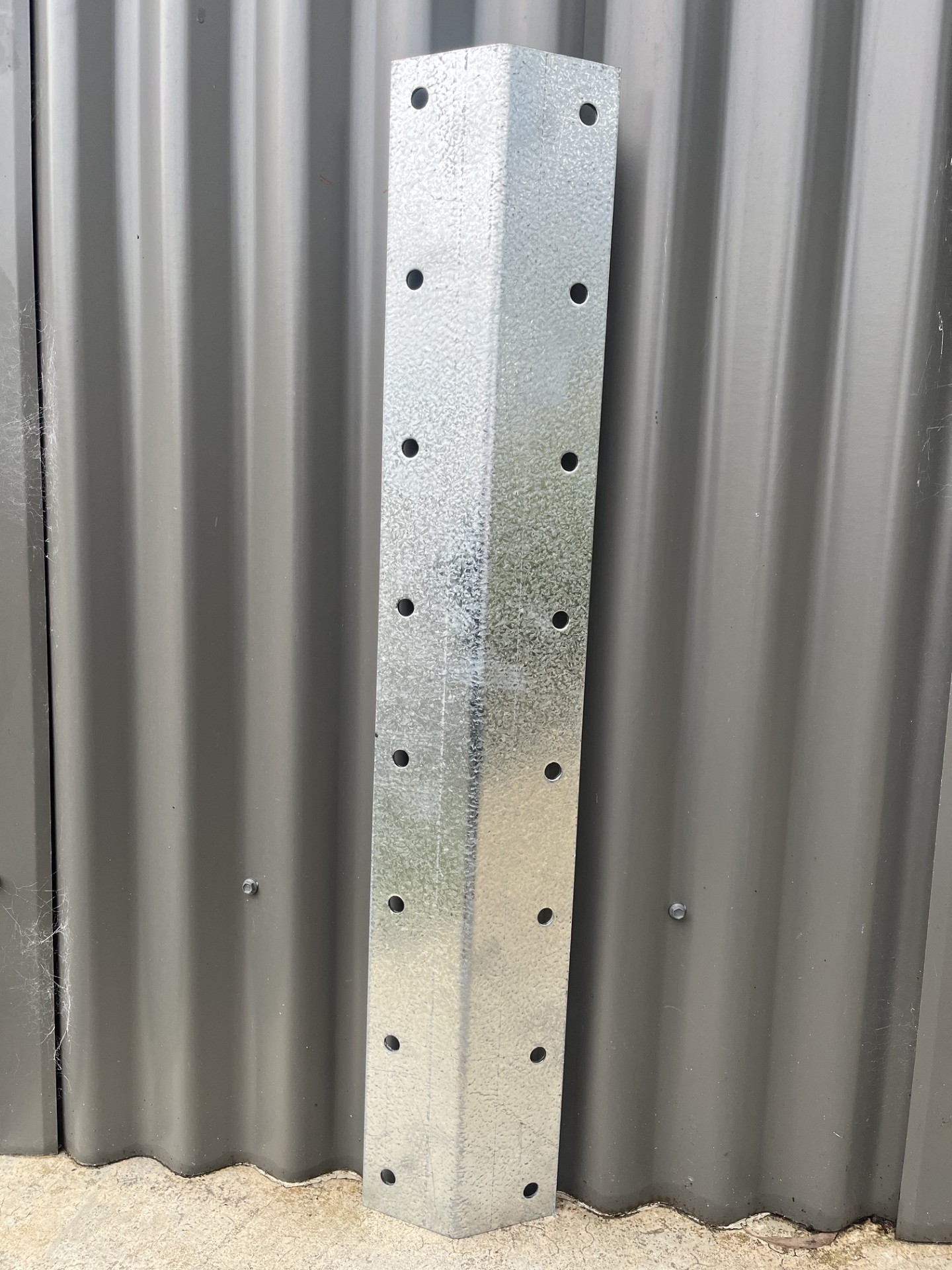 Galvanised steel corner bracket photographed against a shed wall