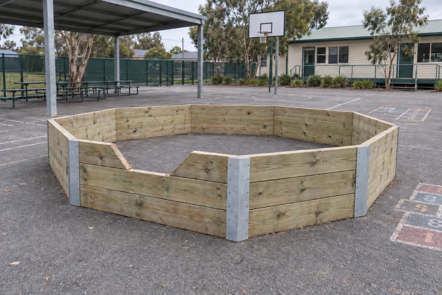 A finished octagonal gaga pit in a school yard: new pine timber walls held together by galvanised steel corner brackets